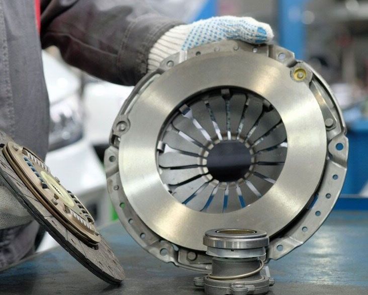 Skilled Worker Holding Car Clutch Plate — Lavington Auto Electrical in Tallangatta, VIC