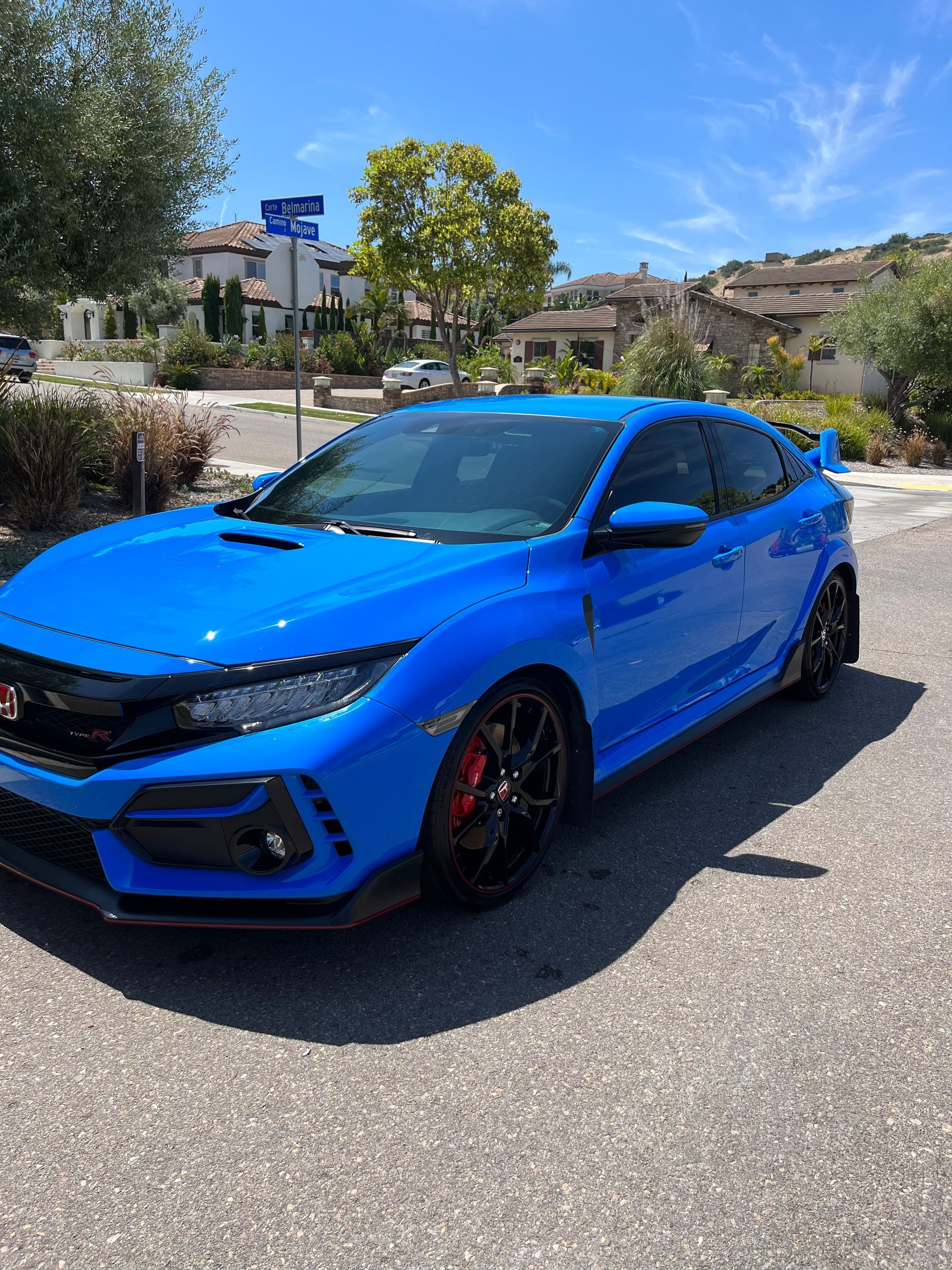 A blue honda civic type r is parked in a parking lot
