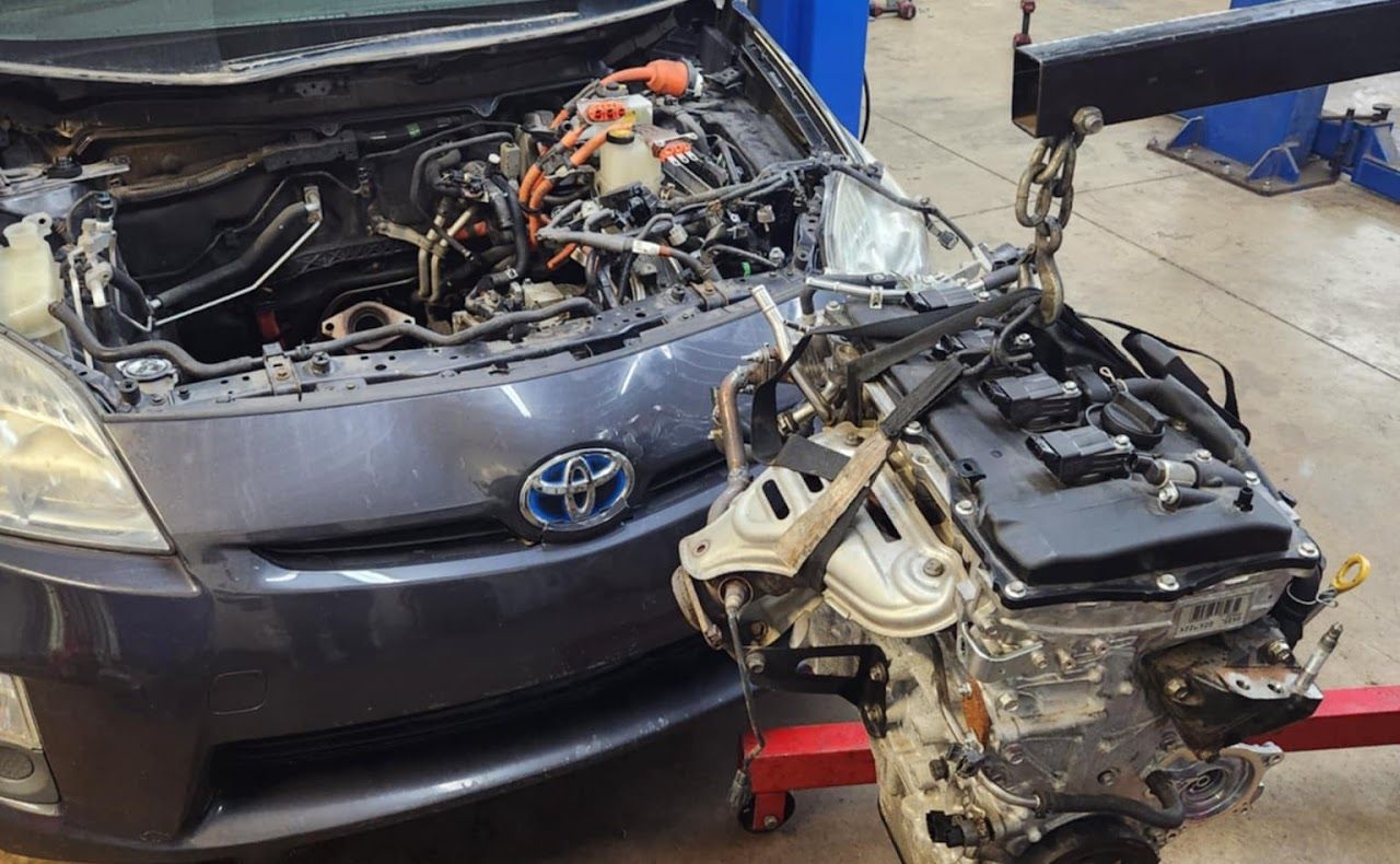 Toyota Prius engine being removed from vehicle in a repair shop | Lucky Autolabs