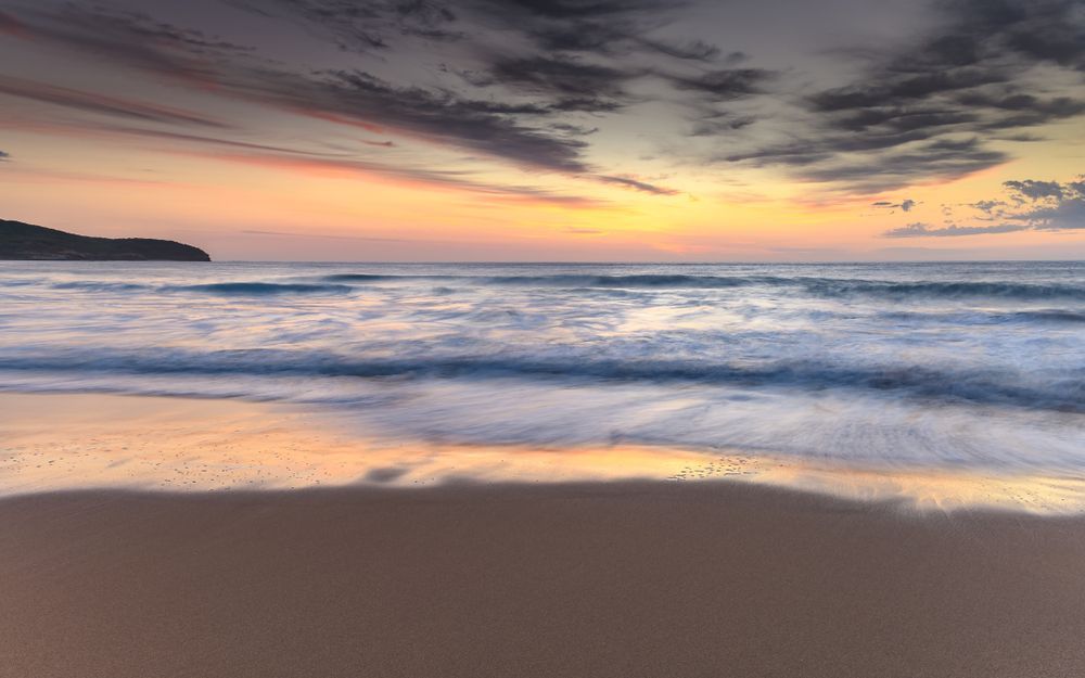 Ocean Waves Washing Onto a Sandy Beach at Sunset; Orange and Purple Sky — Serene Therapy with Lana In Paddington, NSW