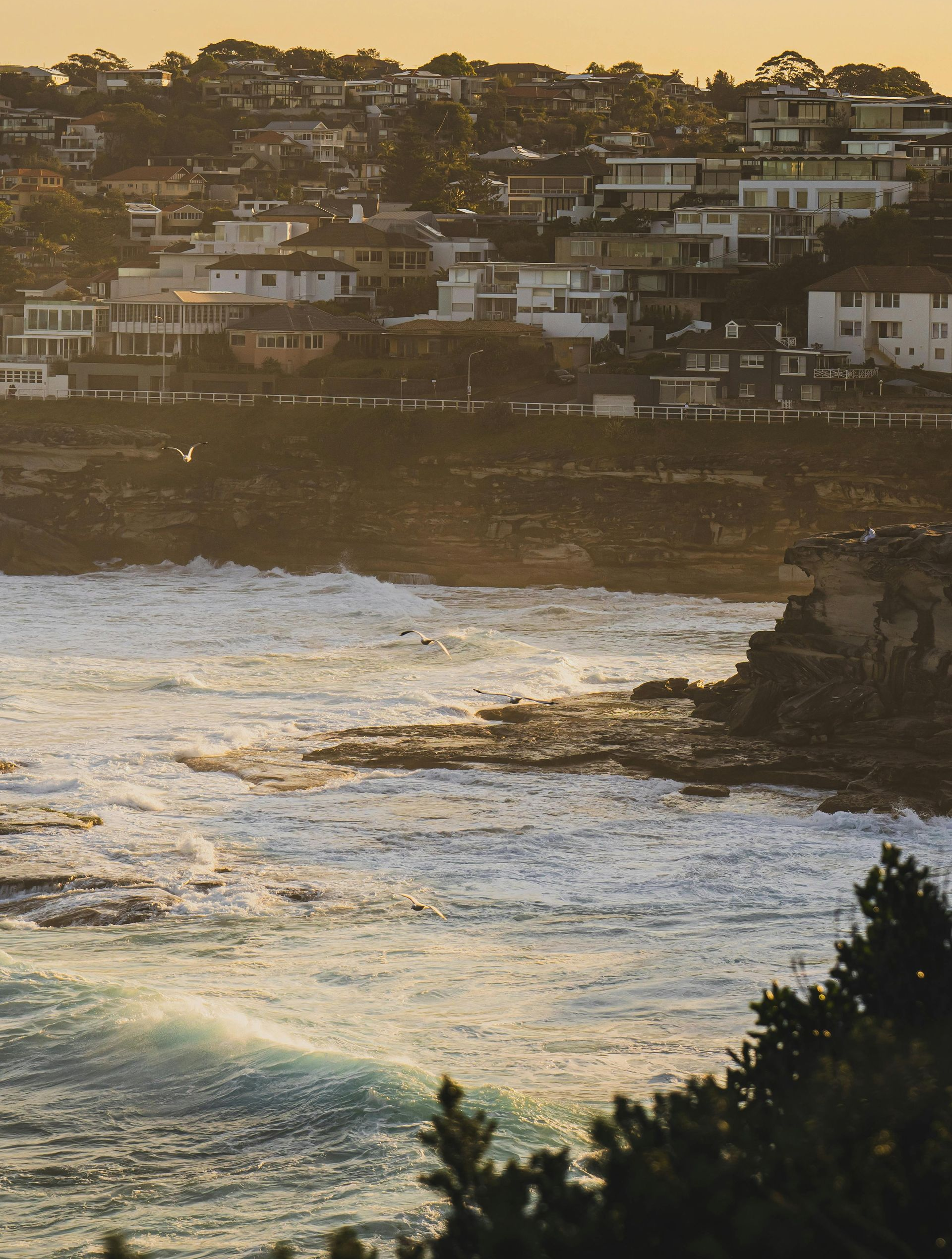 Woman smiling on a beach at sunset, with ocean and rocks in the background. — Serene Therapy with Lana In Paddington, NSW