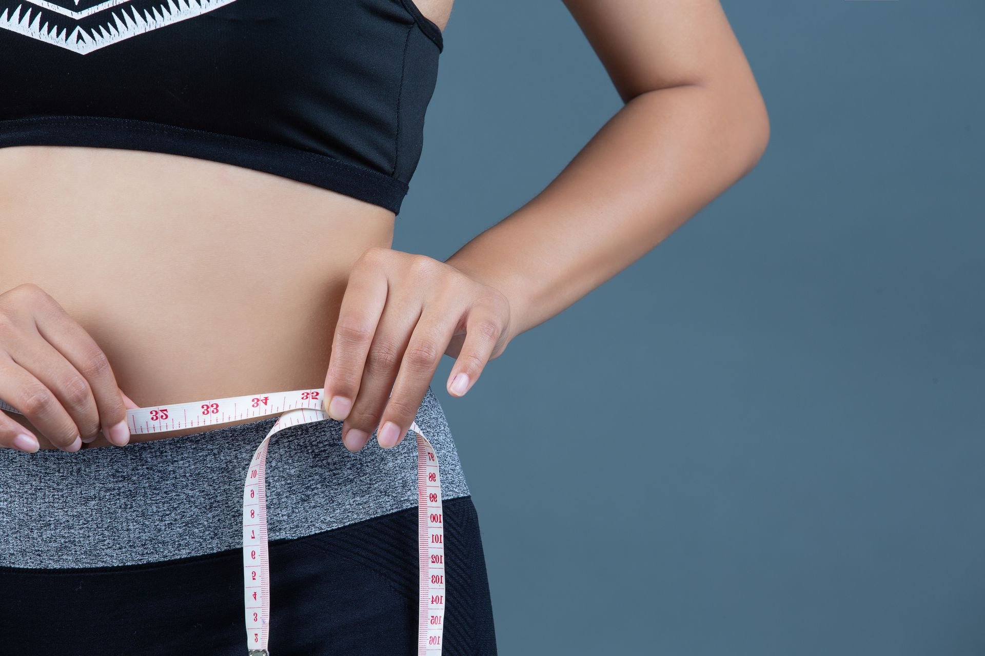 A woman with a towel around her neck is holding her belly