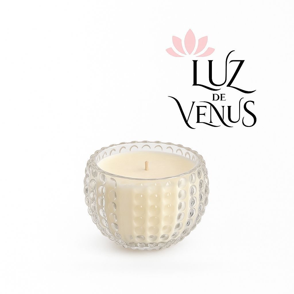 Vela en frasco de vidrio texturizado, cera crema, logo “Luz de Venus” en colores rosa y negro.