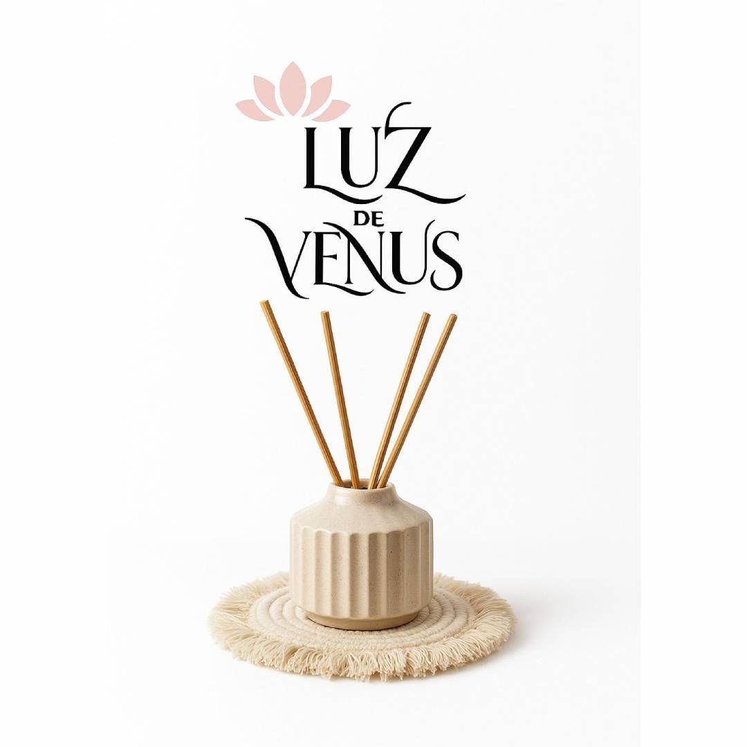 Difusor de color crema con varillas sobre tapete con flecos, logo “Luz de Venus” y flor rosa sobre fondo blanco.