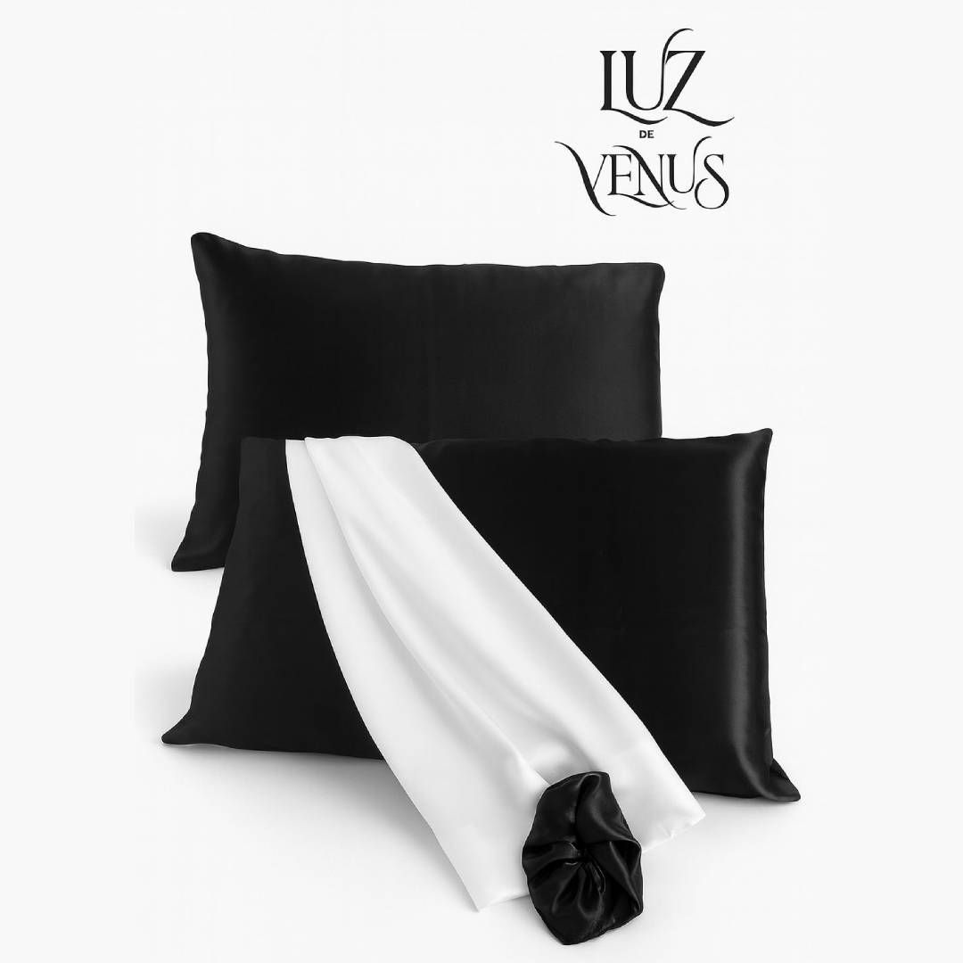 Dos fundas de almohada de seda negra con tela blanca y un coletero negro. El logo de Luz de Venus está en la parte superior.