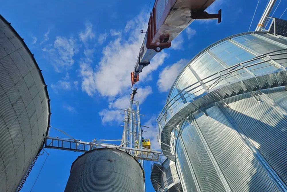 An old crane is sitting in the middle of a field.