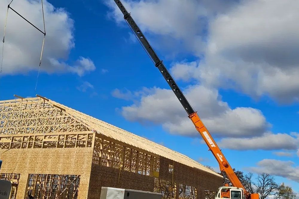 A yellow crane is sitting on top of a construction site.