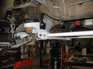 A car is sitting on a lift in a garage.