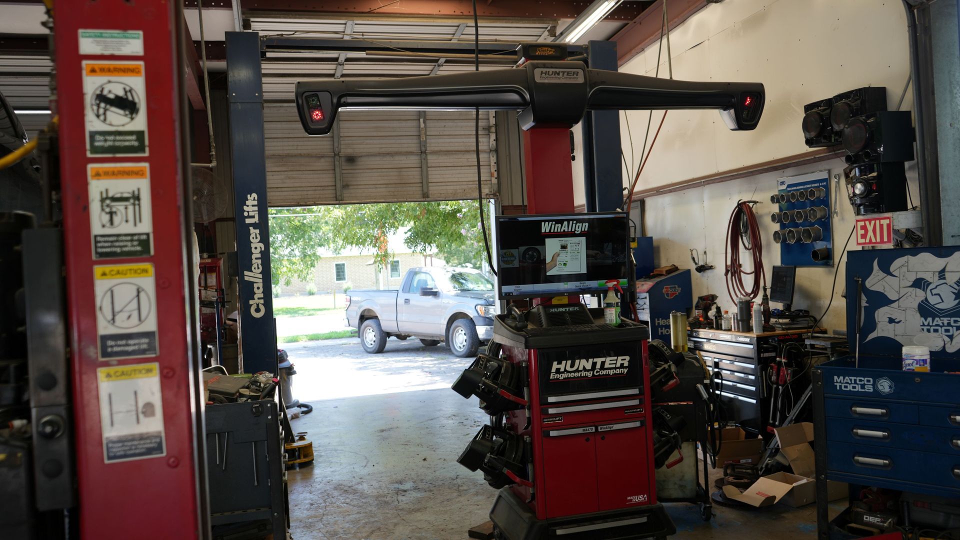 A truck is parked in a garage next to a machine.