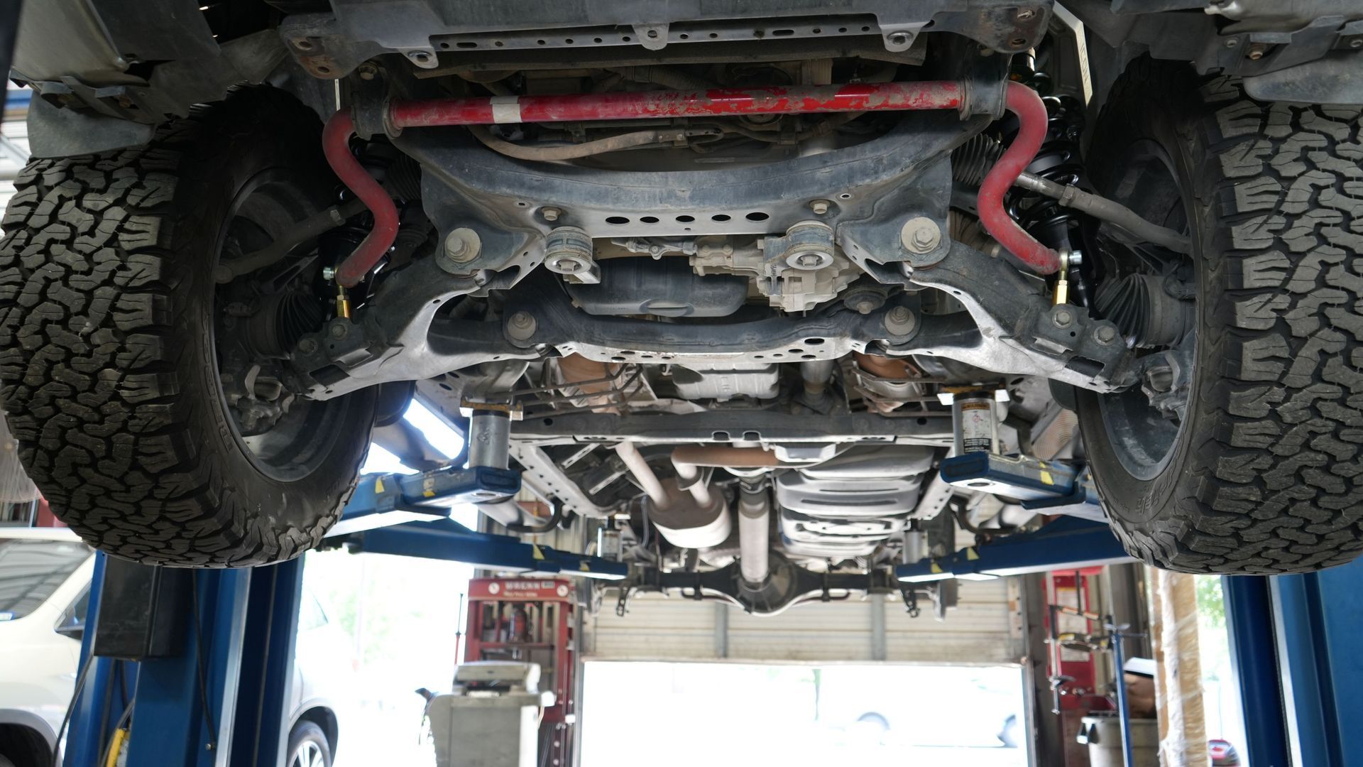 A car is sitting on a lift in a garage.