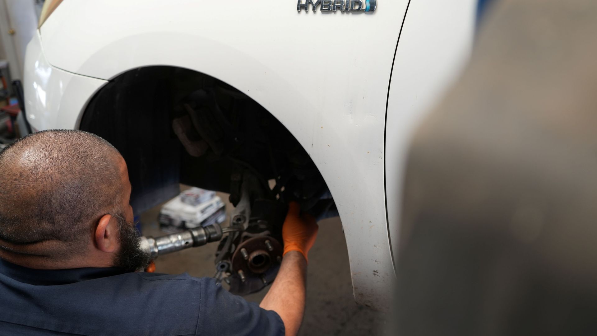 A man is working on a car in a garage.