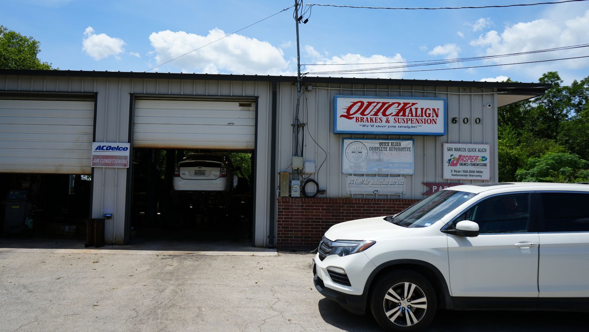 A white suv is parked in front of a garage.