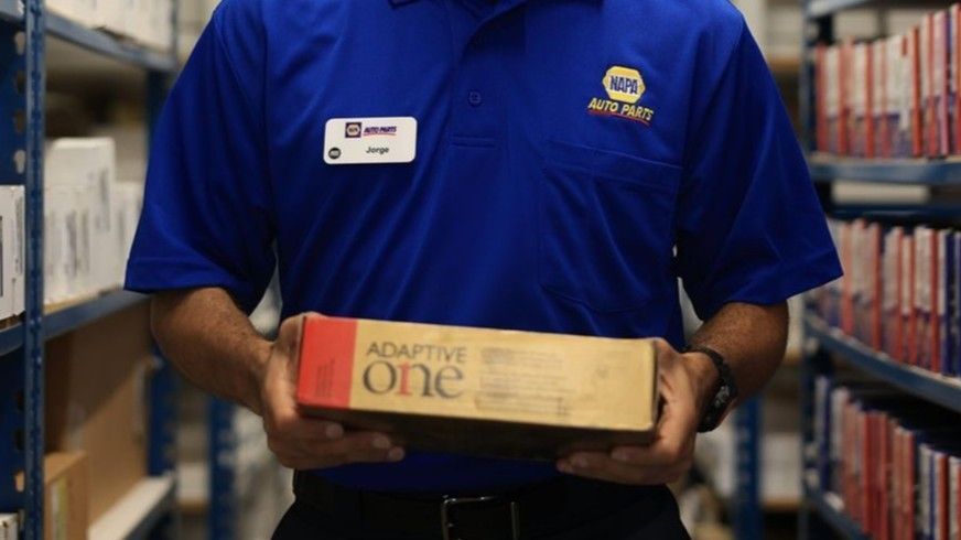 A man in a blue shirt is holding a box that says adaptive one