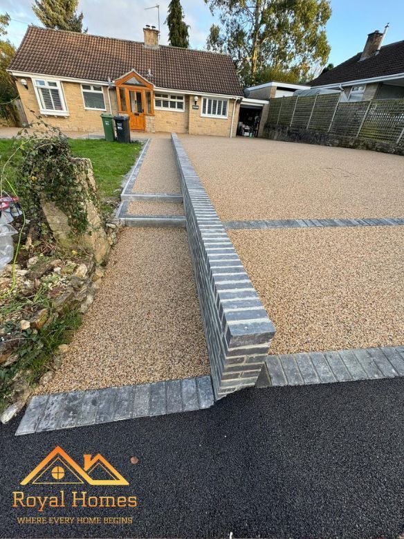 Driveway with gravel, brick wall, and a house. Royal Homes logo at the bottom.
