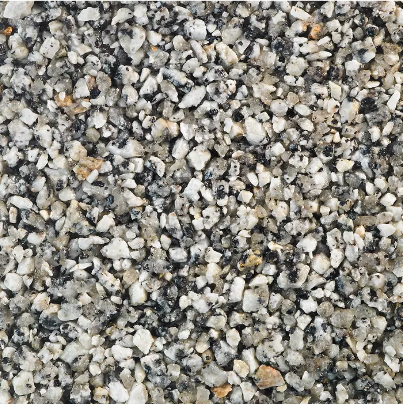Close-up view of small, crushed gravel. Predominantly white, gray, and black stones.