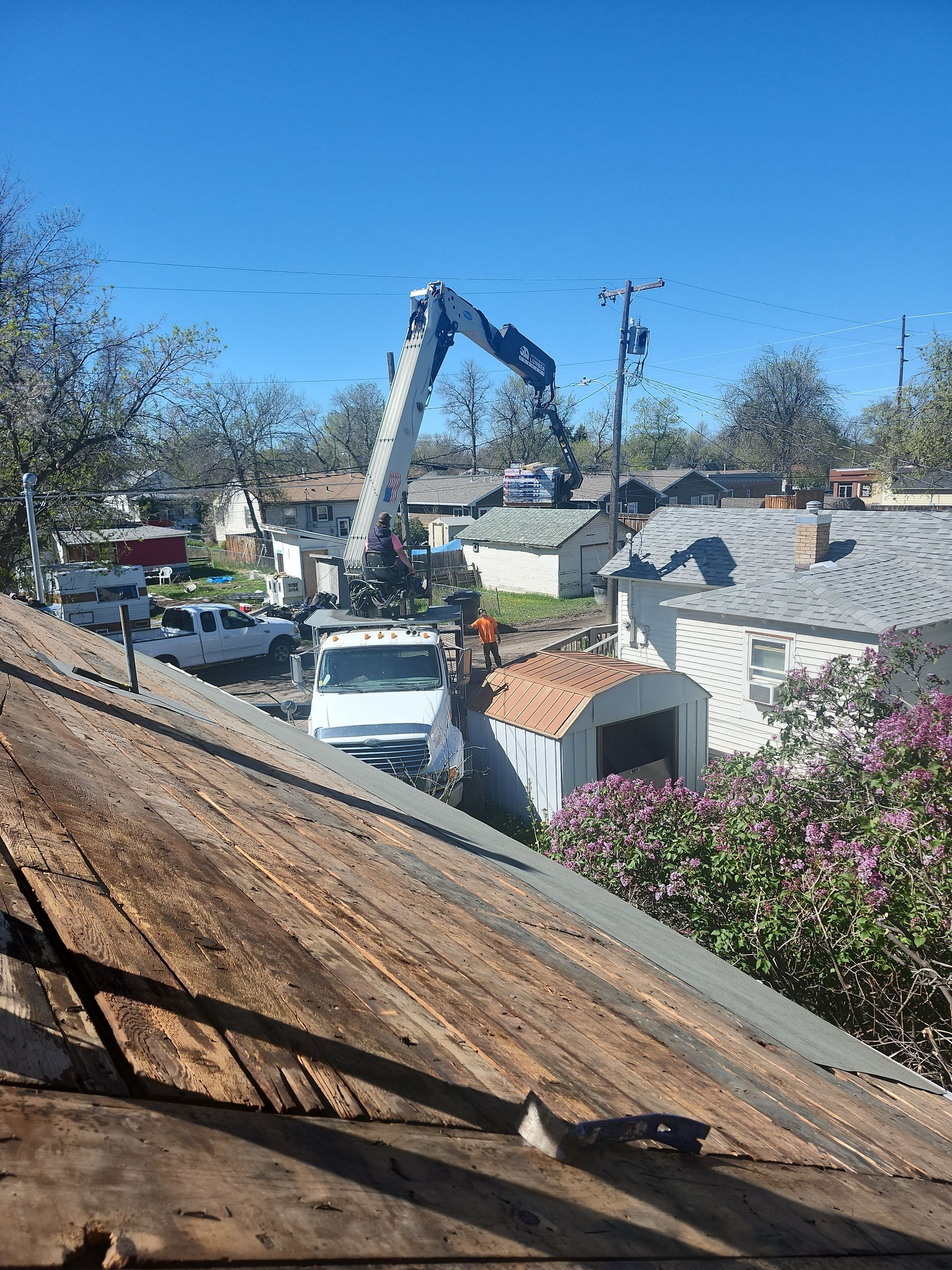 Concrete pump truck on a sunny day pumping concrete, over old houses.