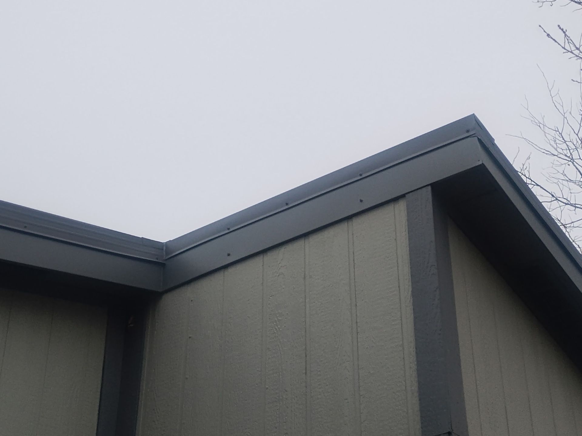 Gray roofline of a building against a cloudy sky.