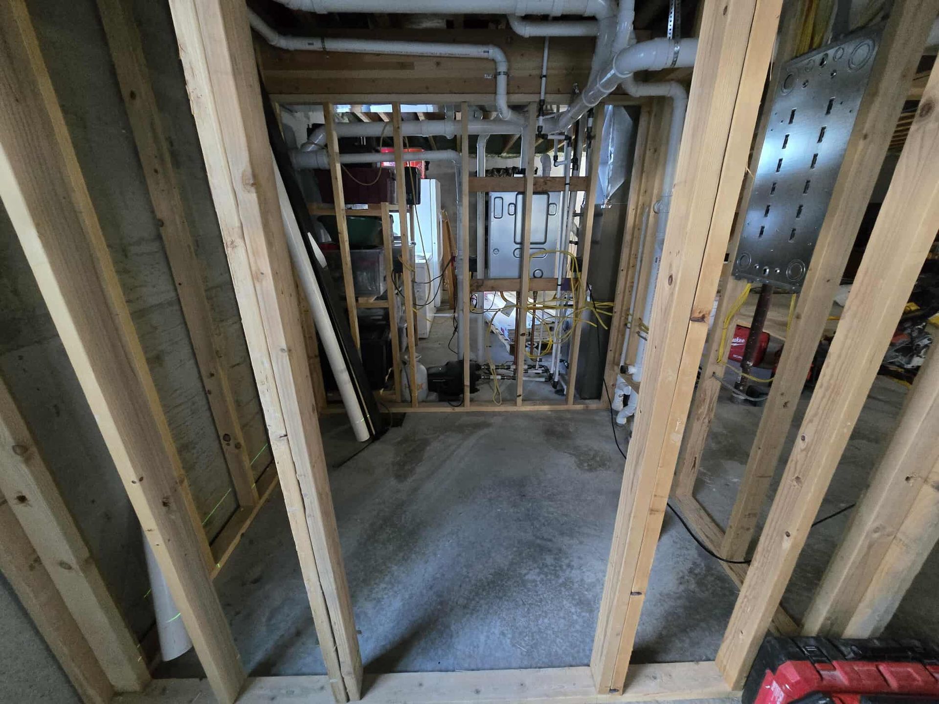 Framing of a doorway leading to a utility room in a basement under construction.