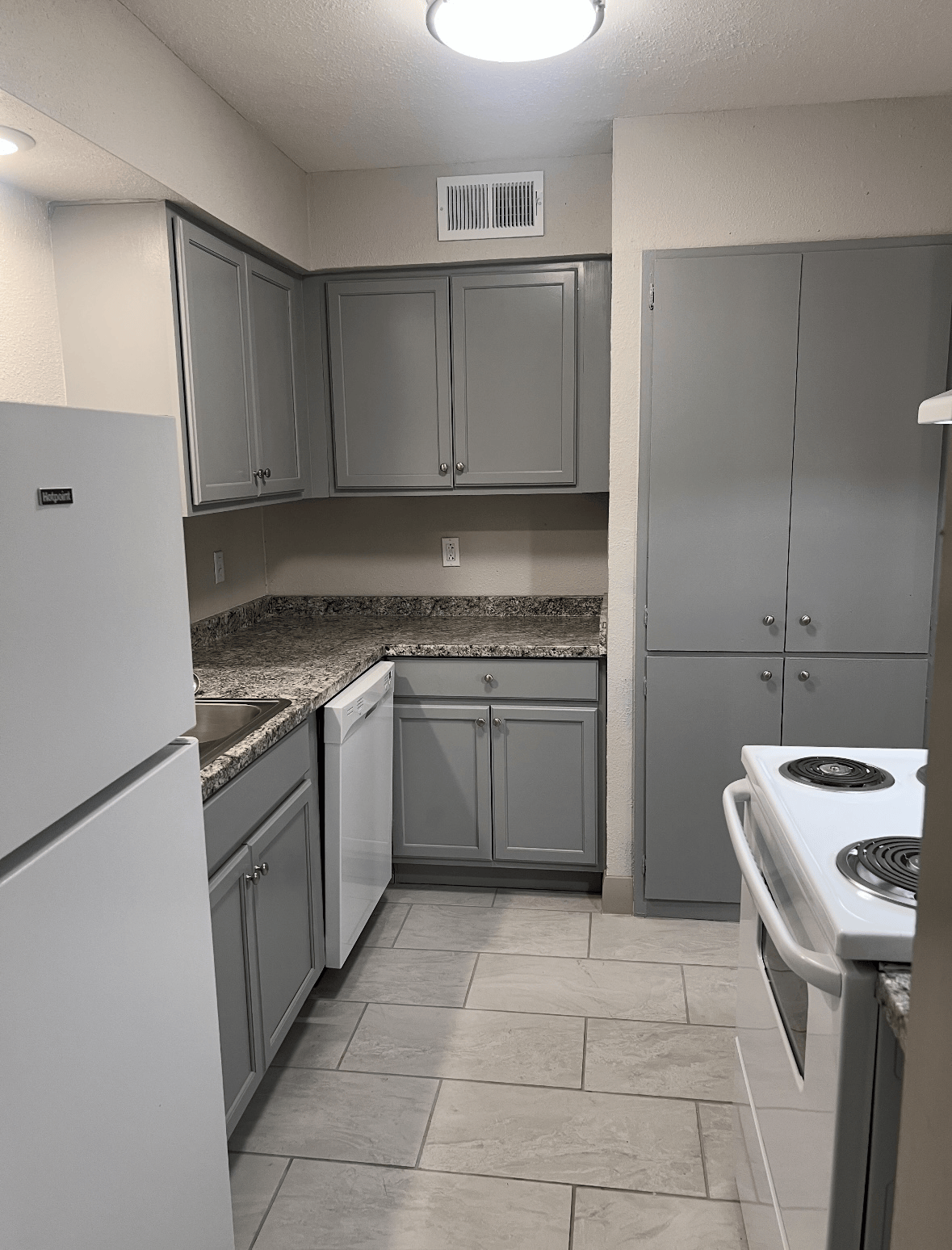 Kitchen with grey cabinets and light fixtures 