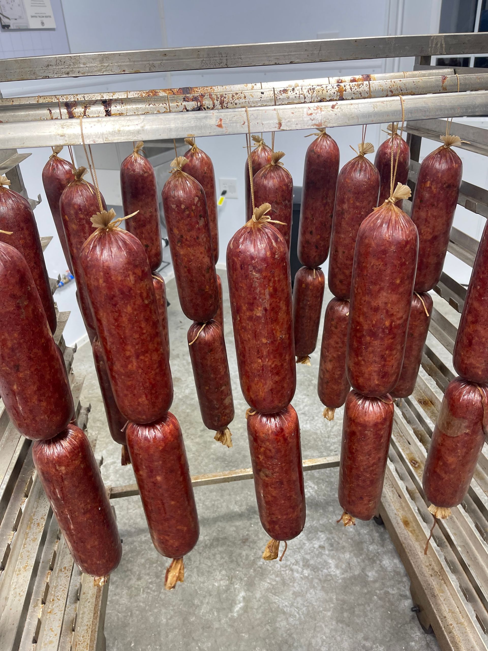 A bunch of sausages are hanging from a rack.