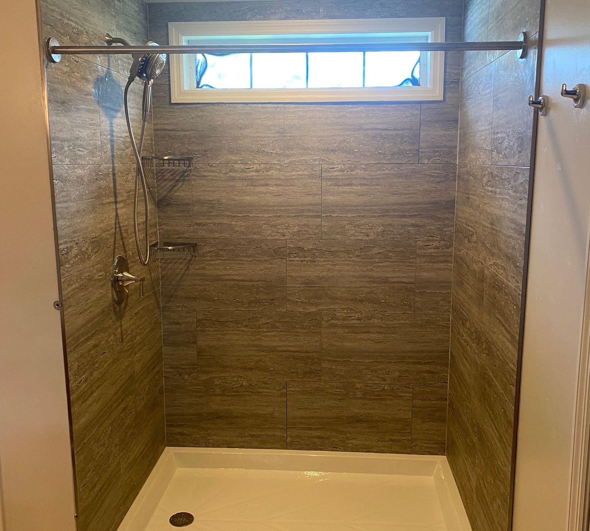 A shower with a window and a shower head