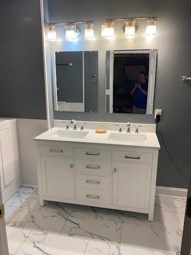 A bathroom with two sinks and a mirror.