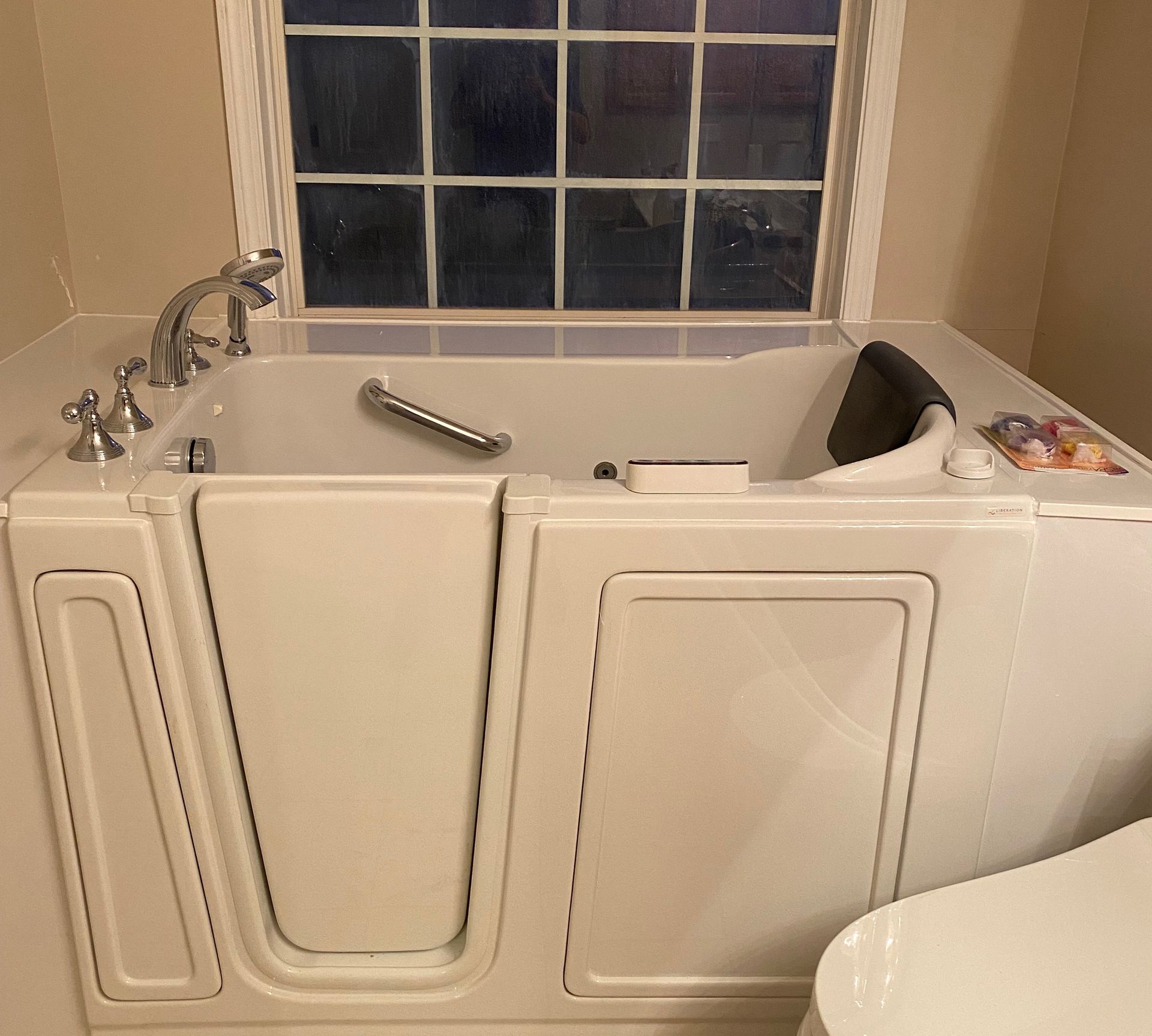 A walk in tub in a bathroom next to a toilet.