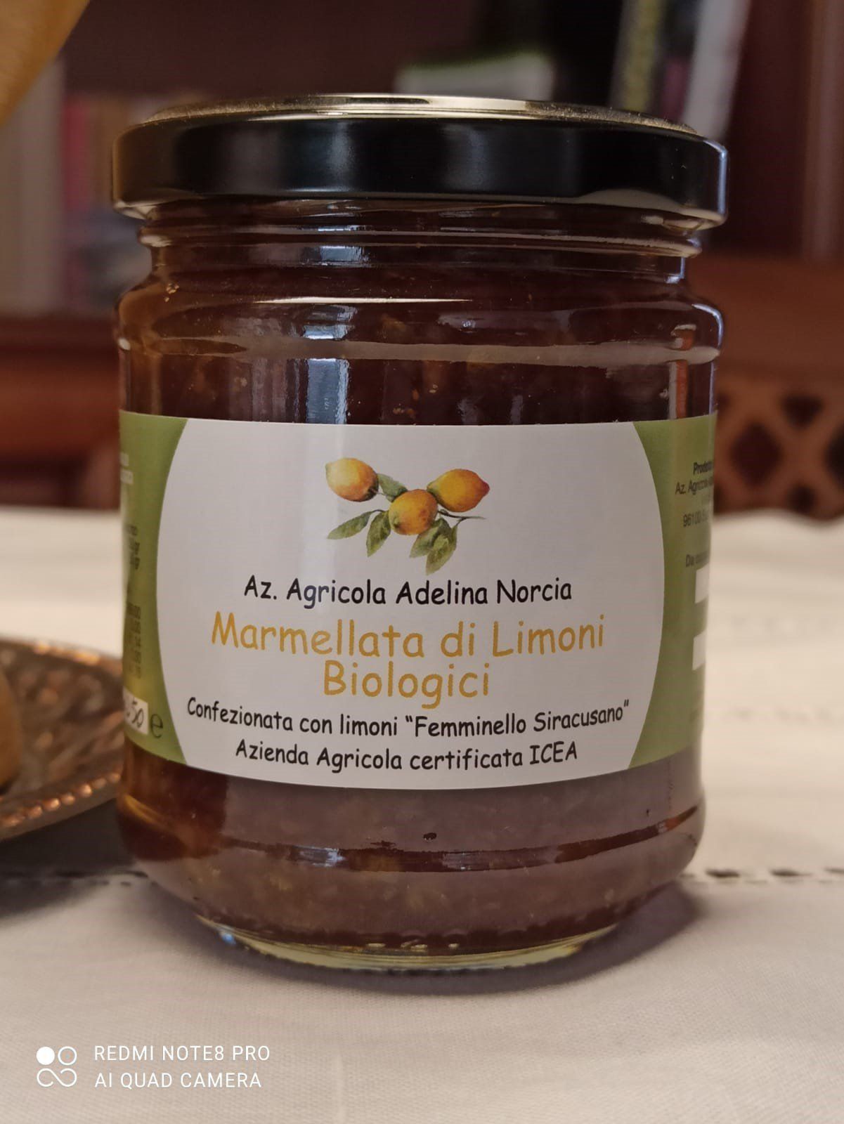 Barattolo di marmellata di limoni con etichetta, appoggiato su un tavolo.