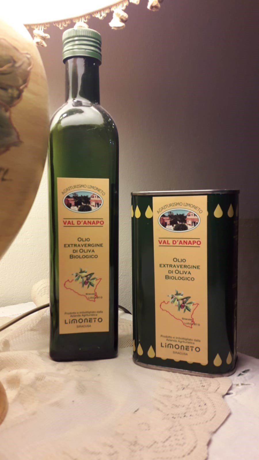 Due bottiglie verdi di olio d'oliva con l'etichetta
