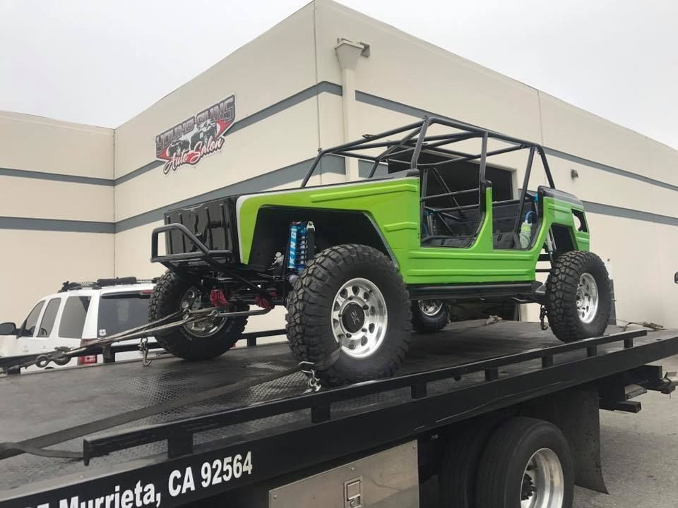 Bright green off-road vehicle on a flatbed truck, ready for transport. In Murrieta, CA.