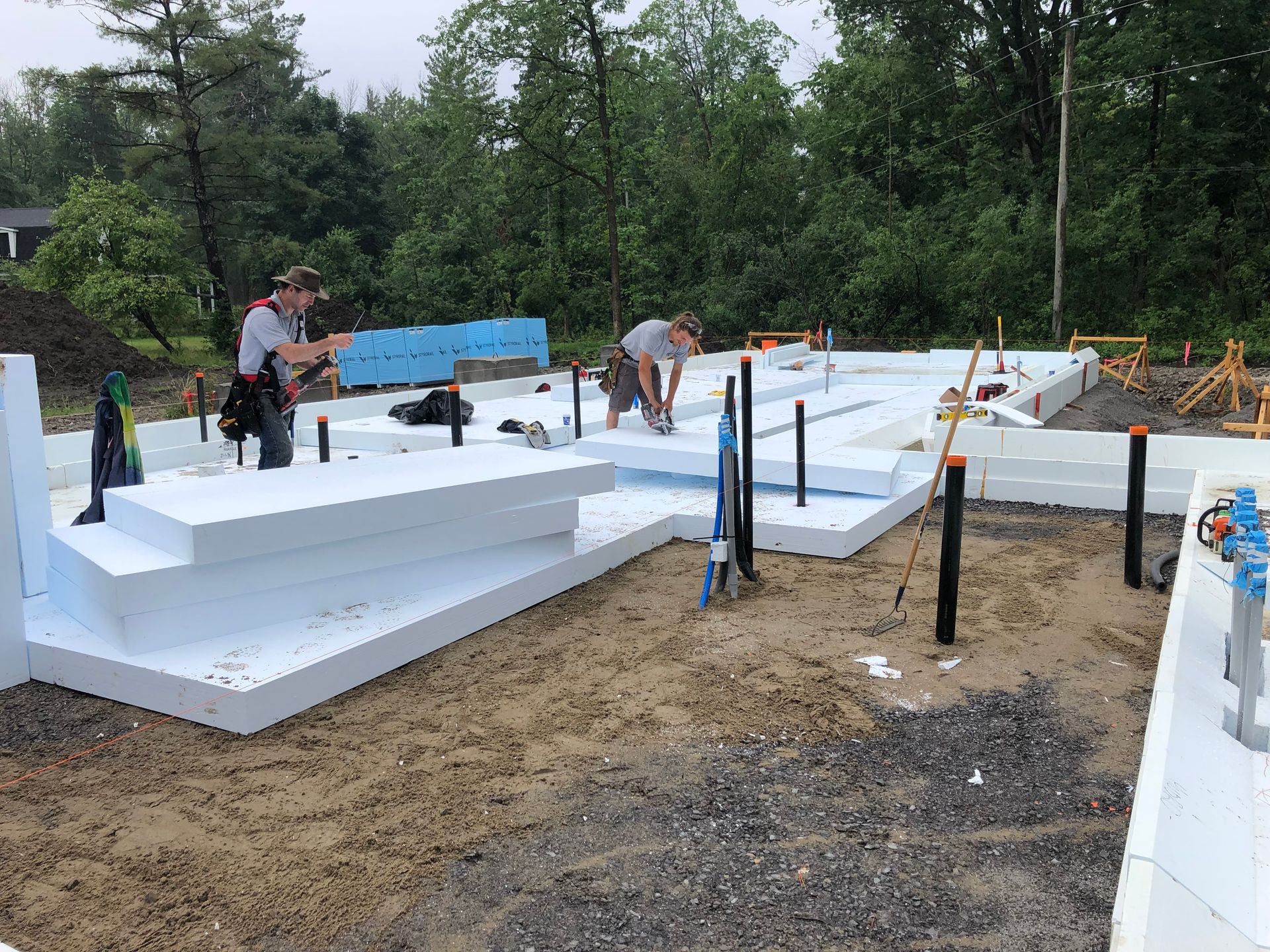 Construction workers building a foundation with insulated concrete forms outdoors.