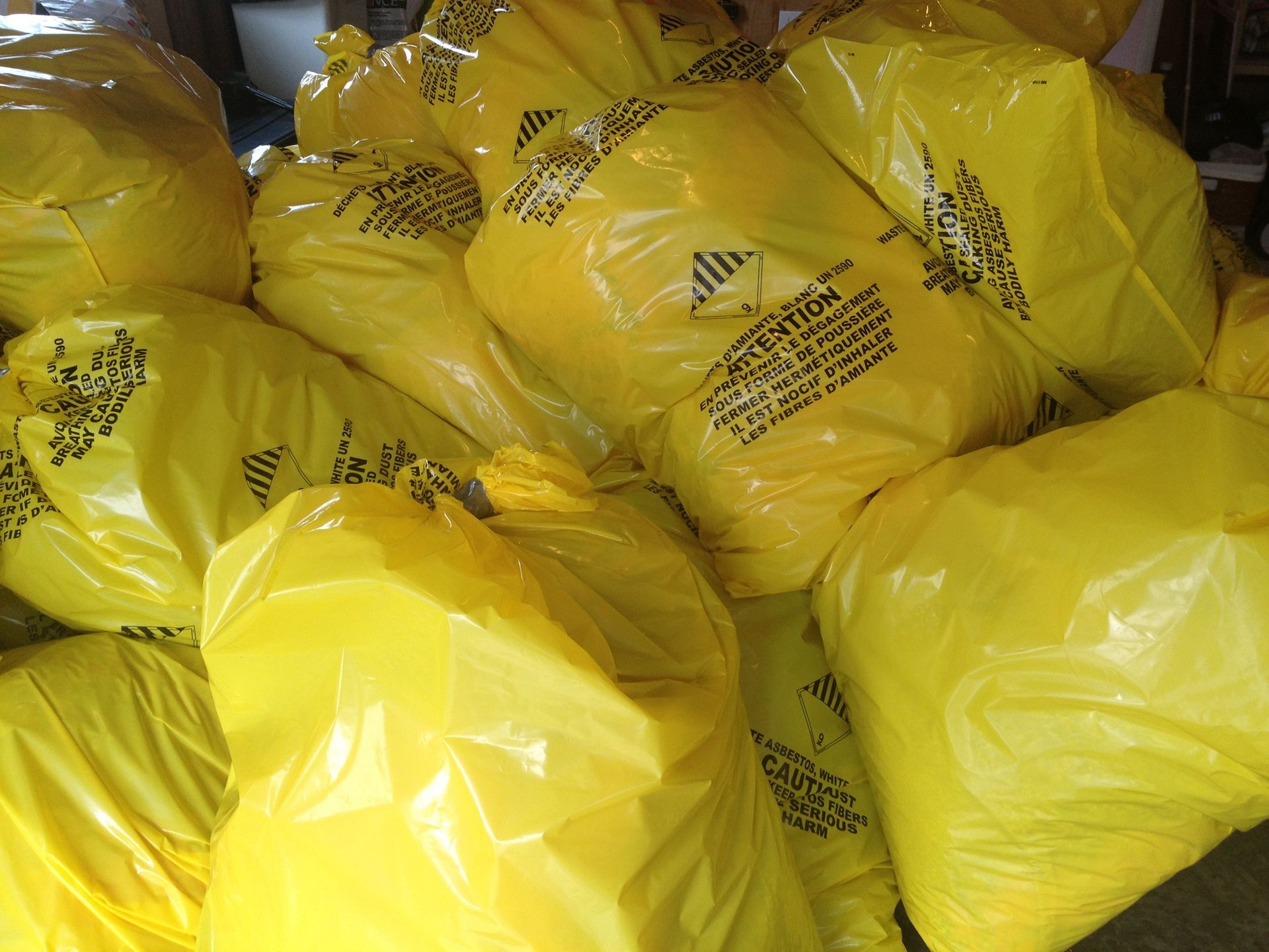 Yellow bags piled together, possibly containing waste or hazardous materials.