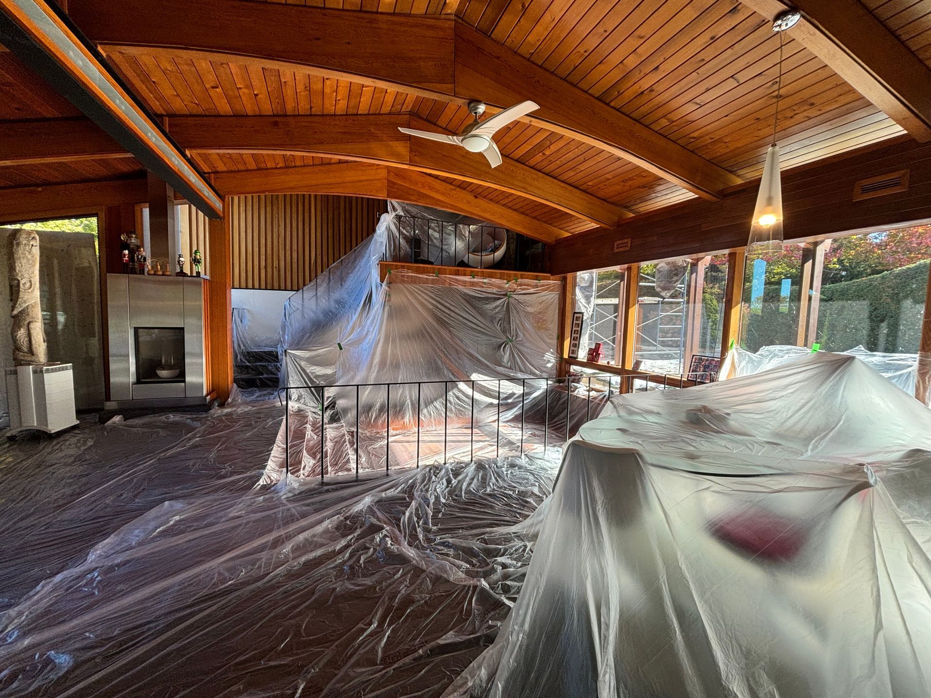 Interior with plastic sheeting covering furniture and surfaces, in preparation for painting or renovation.