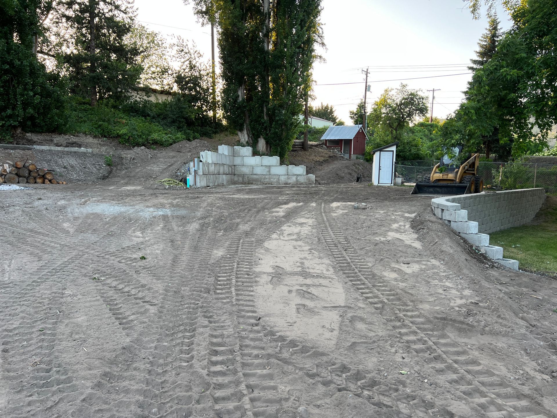 A construction site with a lot of dirt and a bulldozer in the background.