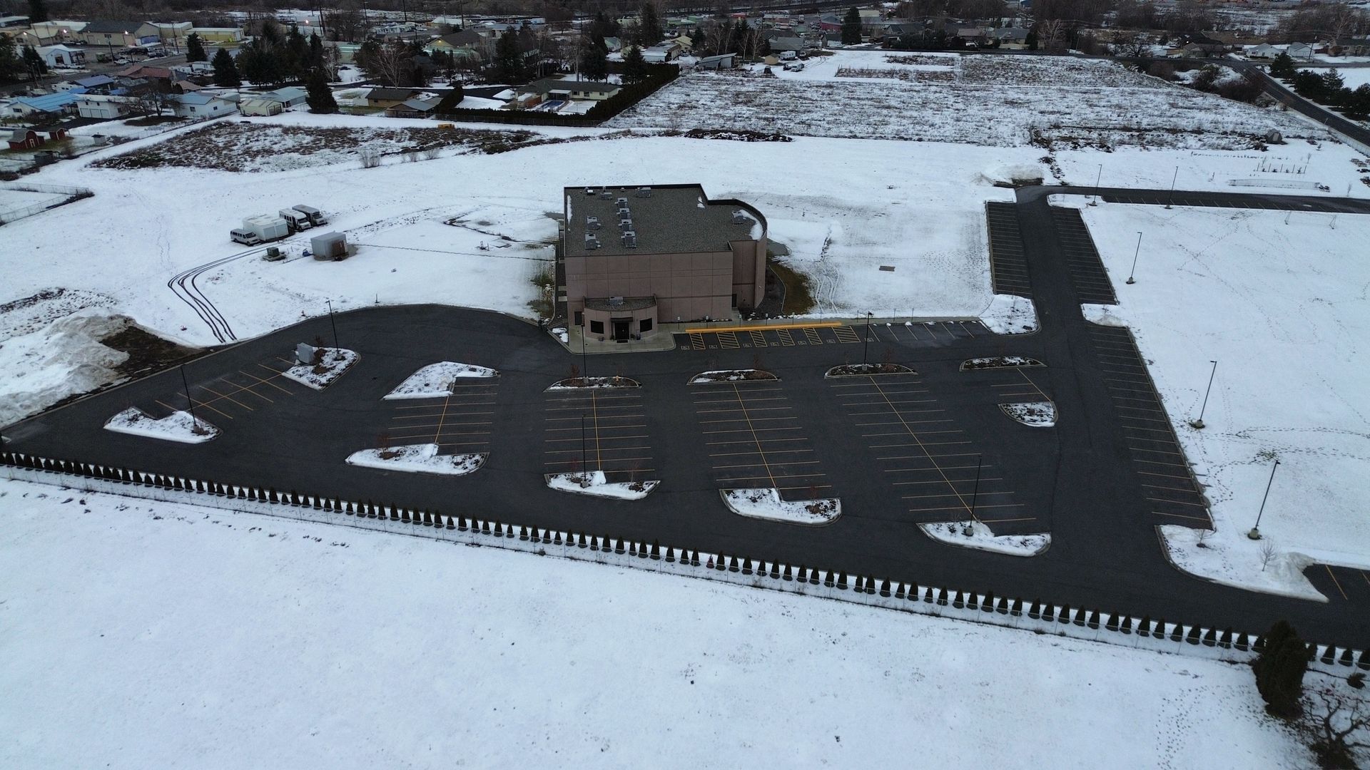 An aerial view of a parking lot covered in snow