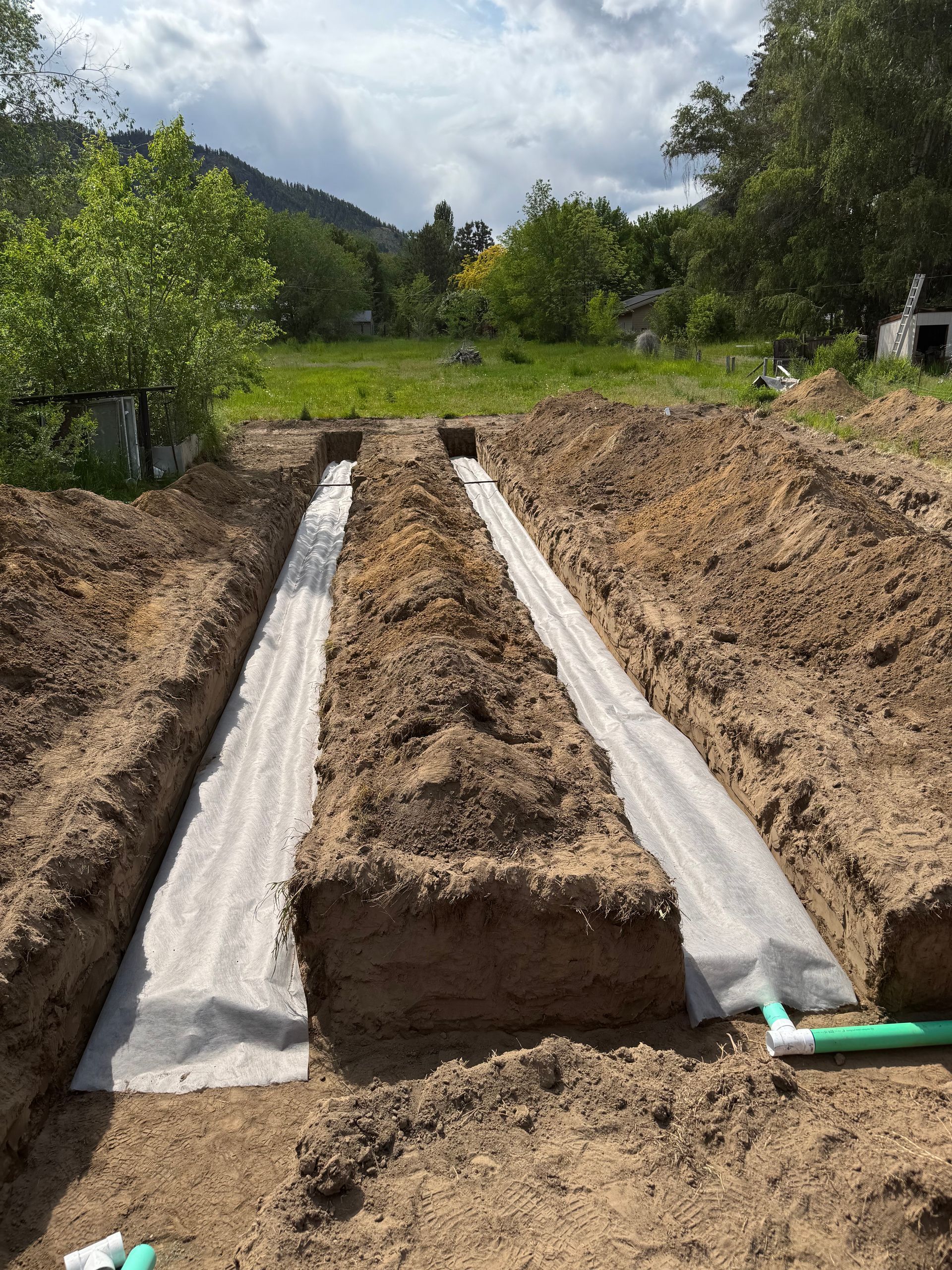 A drainage system is being built in a dirt field.