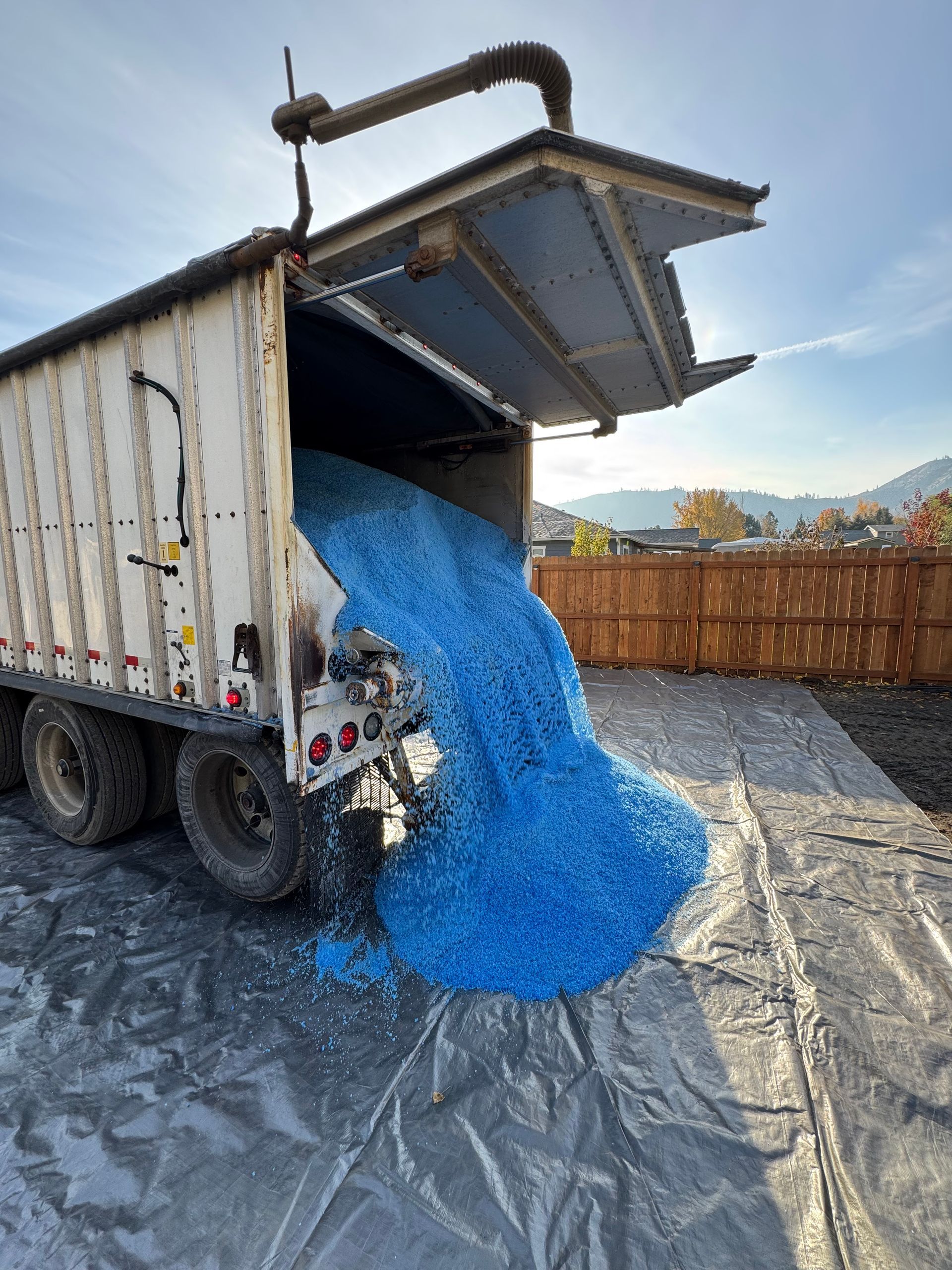 A truck is being loaded with blue plastic bottles.