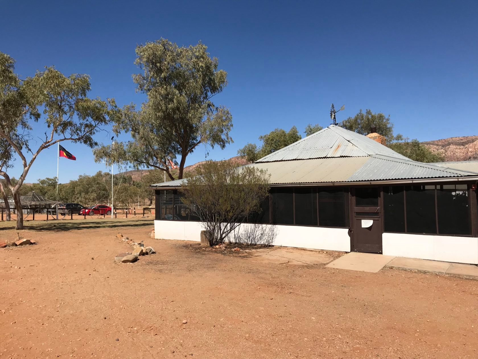 Historic building with a flag, in a dry, desert landscape.