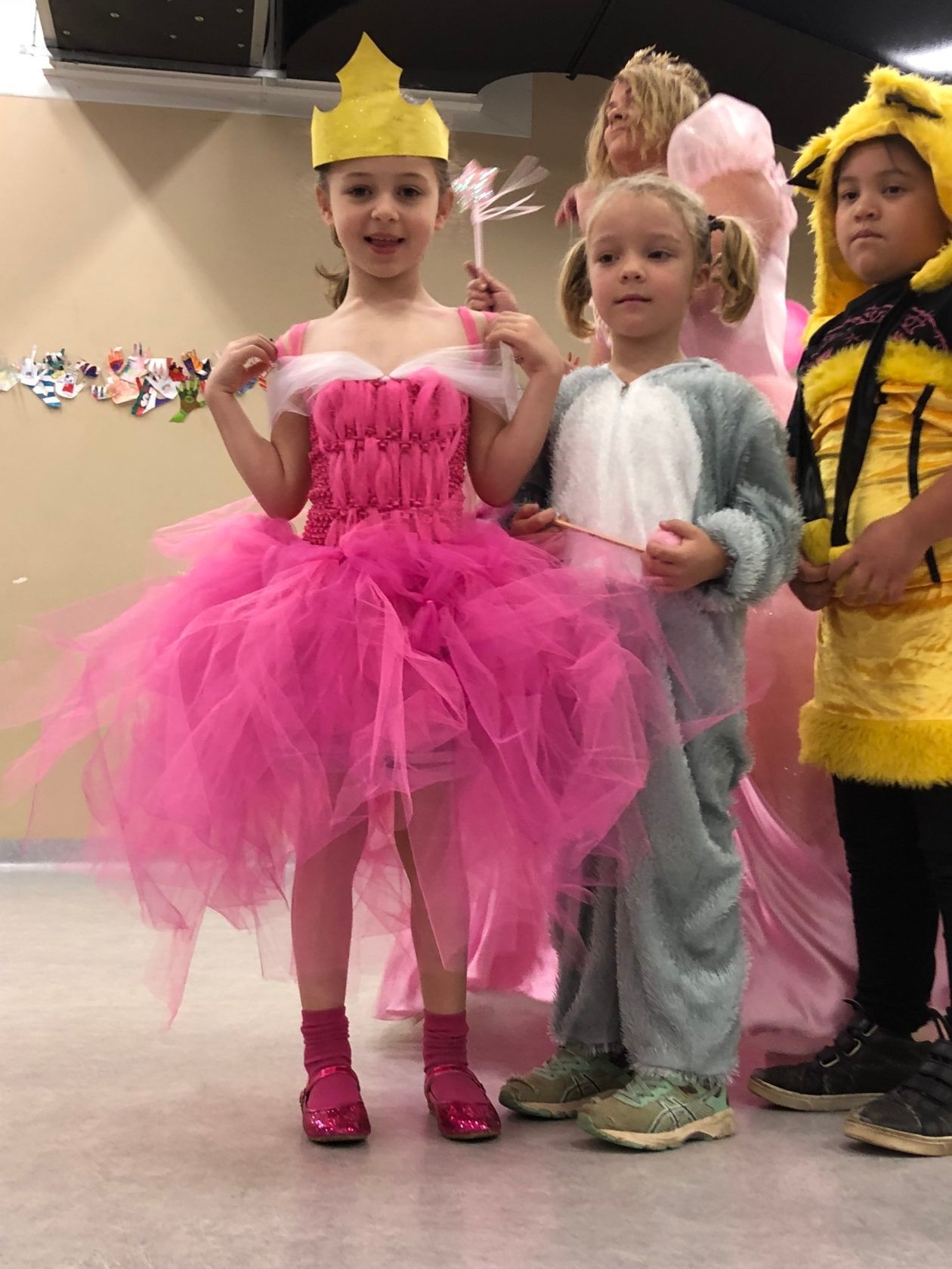 Children in costumes: princess, mouse, and bee posing indoors.