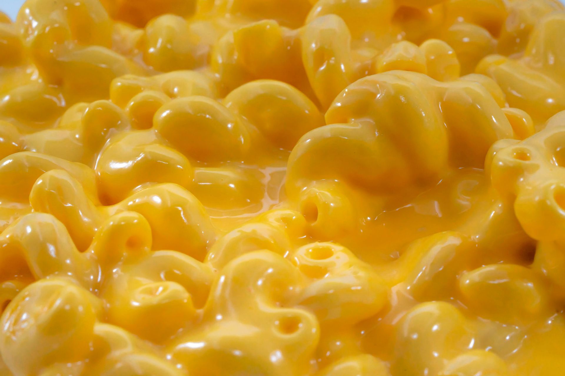 A bowl of macaroni and cheese with a spoon in it.