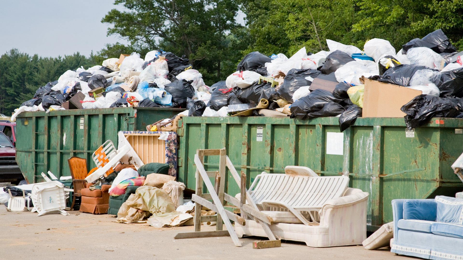 Homeowner loading household junk into small dumpster rental container