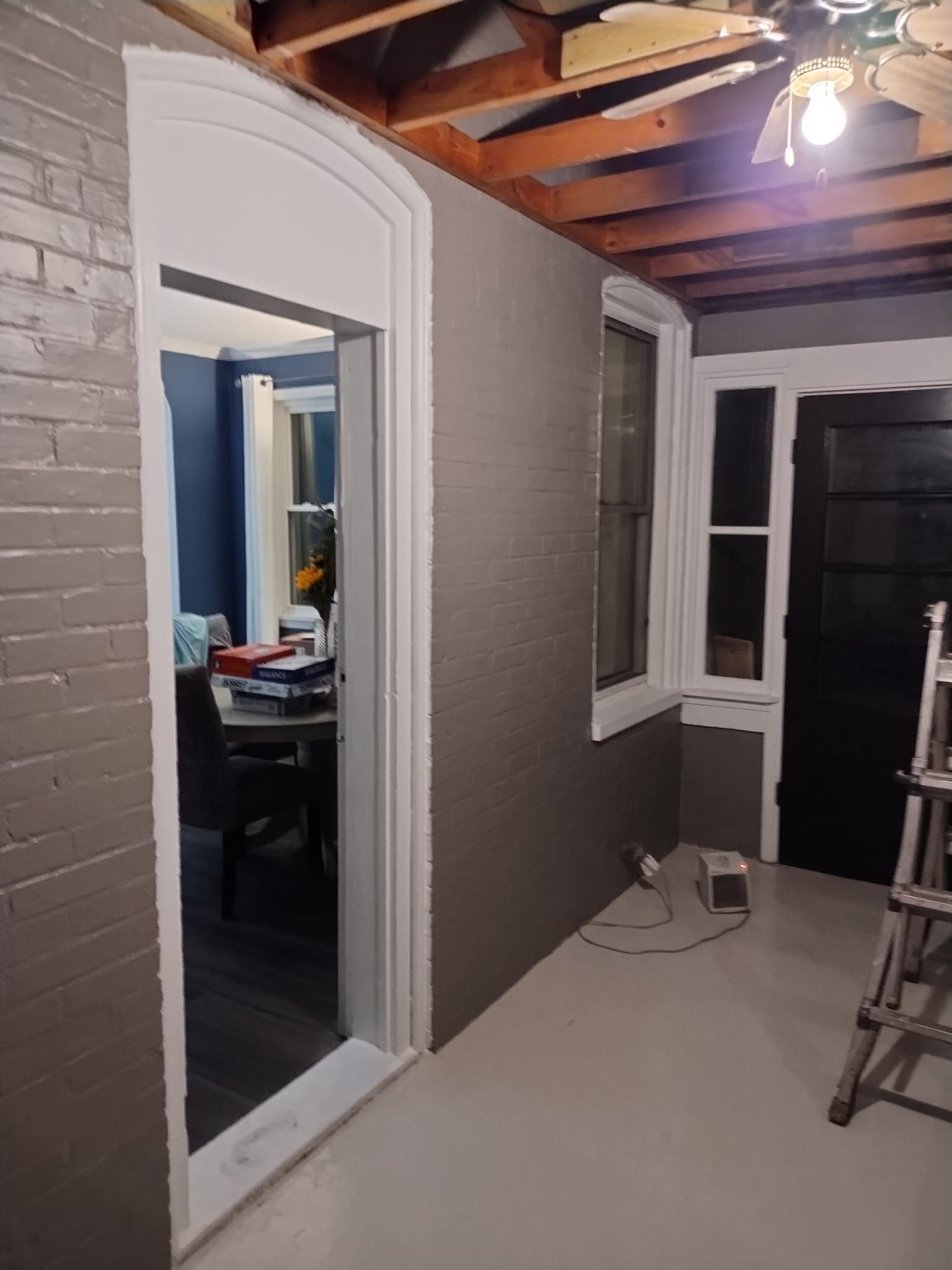 Interior room with gray walls, white trim, and a doorway leading to another room.