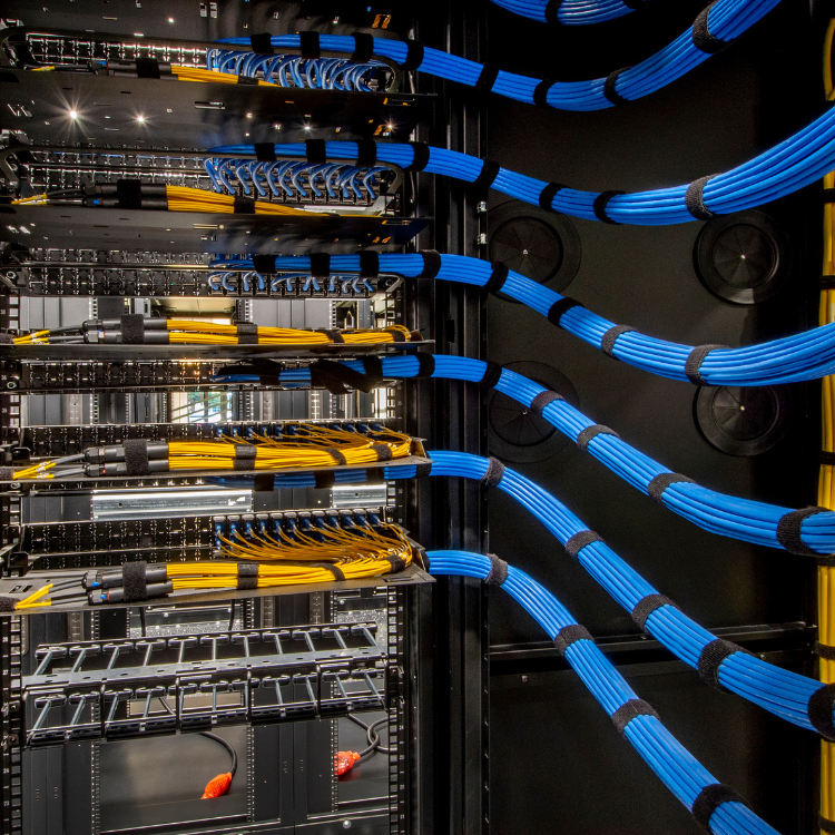 A bunch of blue and yellow wires in a server rack