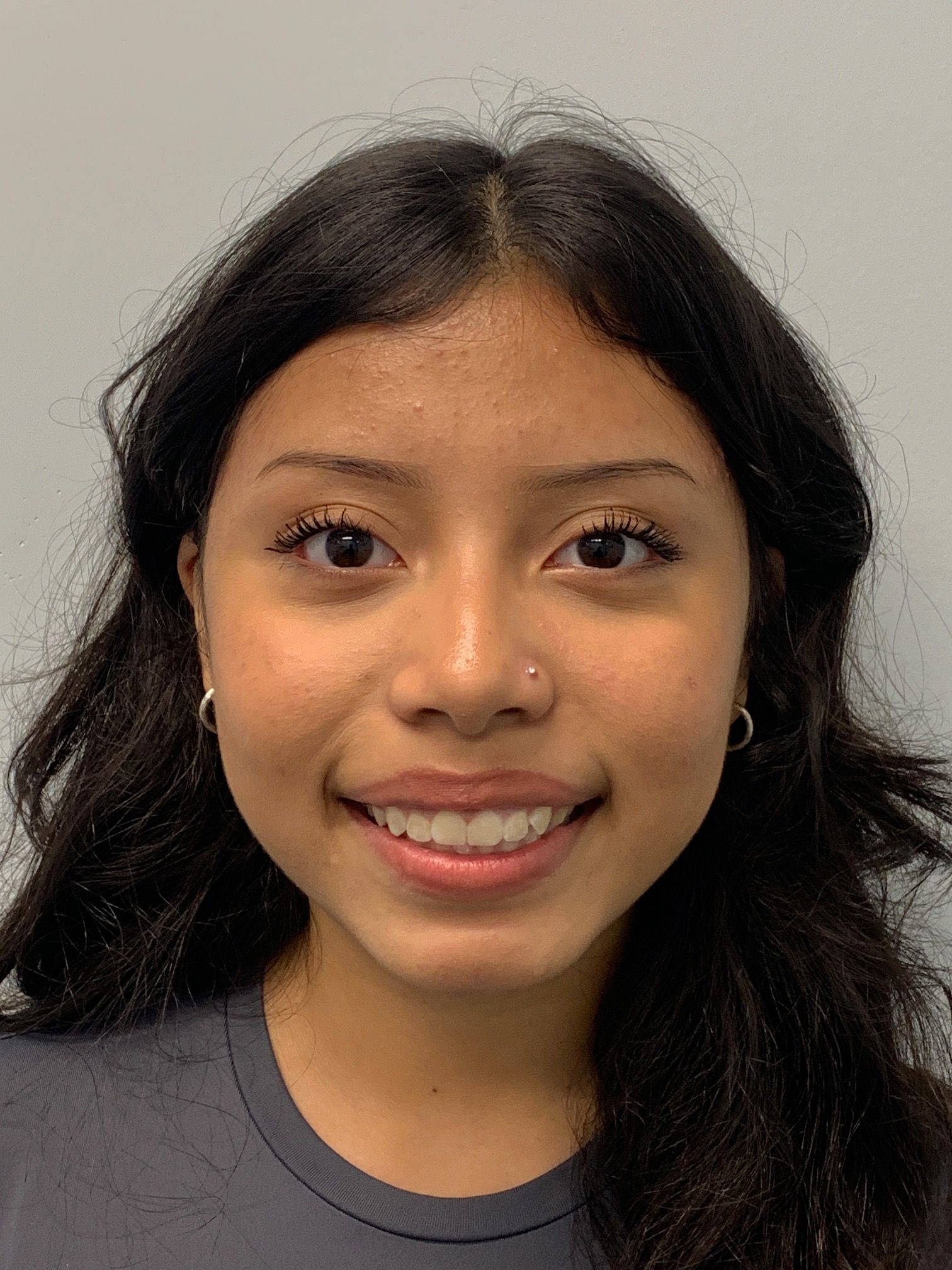 A young woman with long dark hair is smiling for the camera.