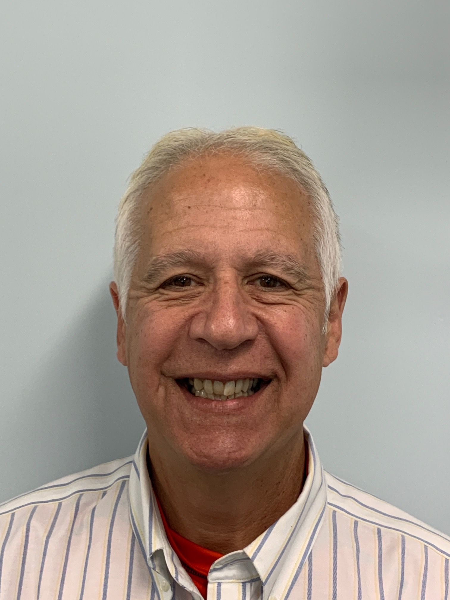 A man in a striped shirt is smiling for the camera.