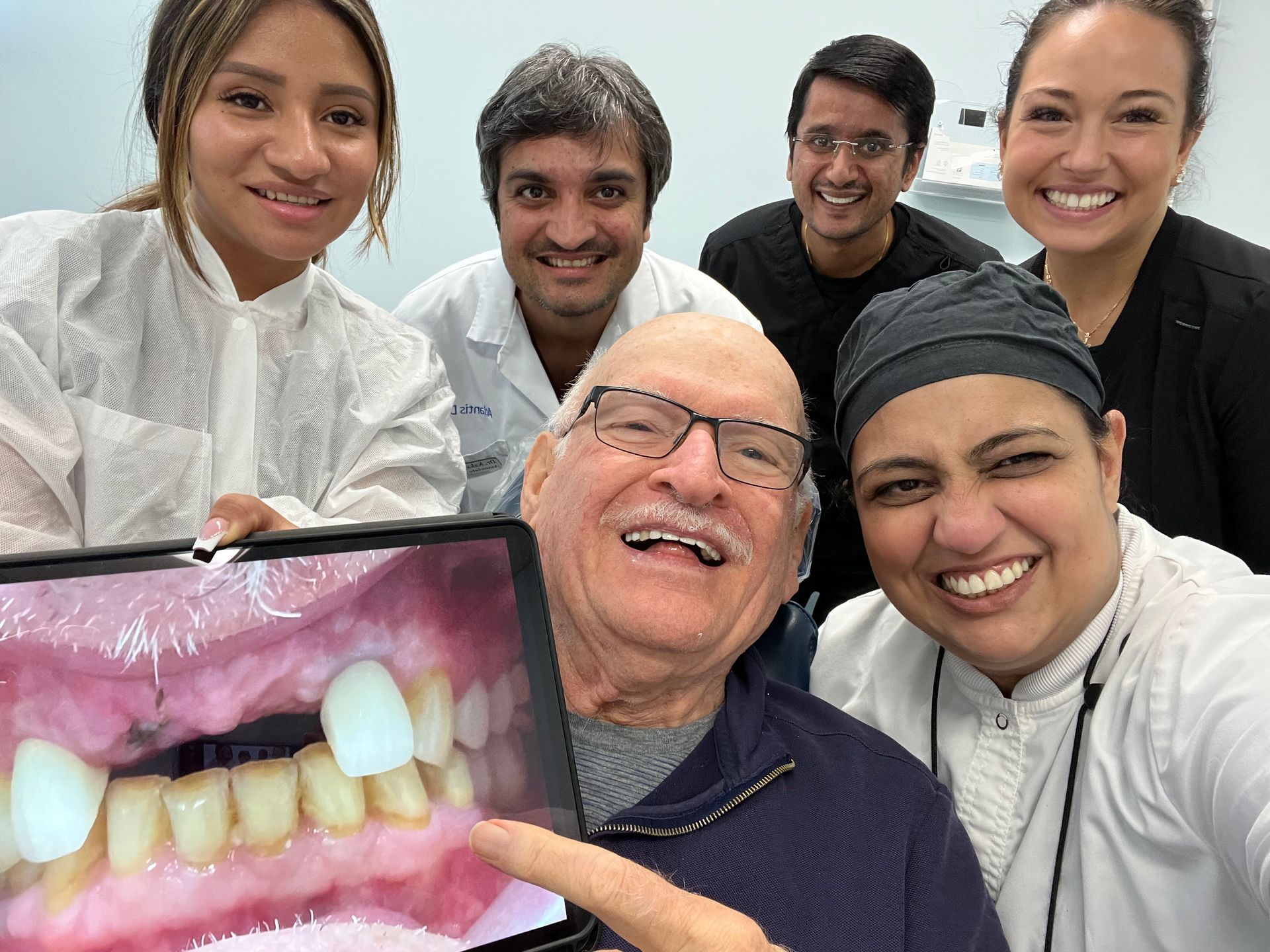 A group of people are posing for a picture in a dental office.