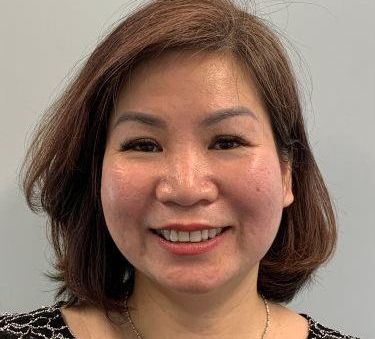 A woman with short brown hair is smiling for the camera.