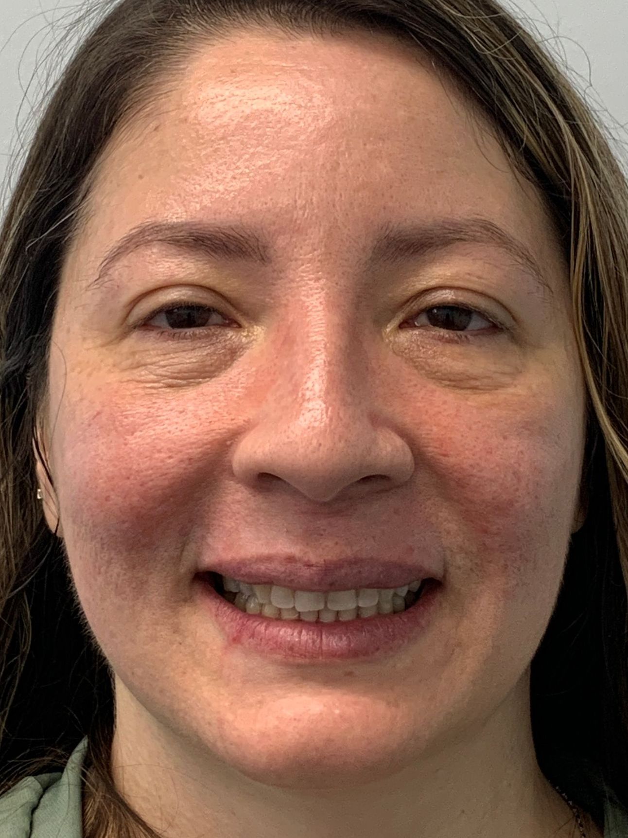 A woman with long hair is smiling for the camera.