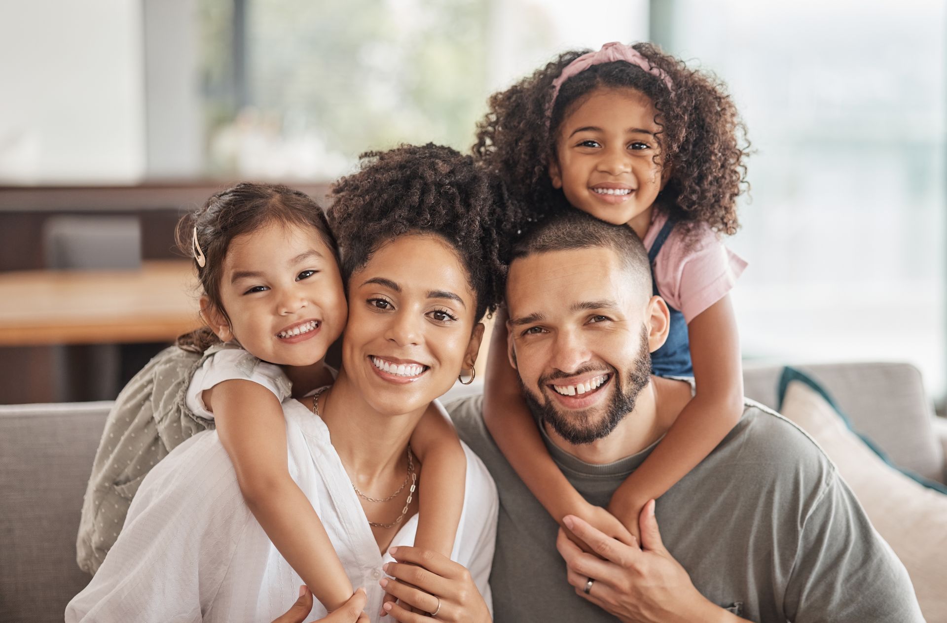 A family is posing for a picture while sitting on a couch.