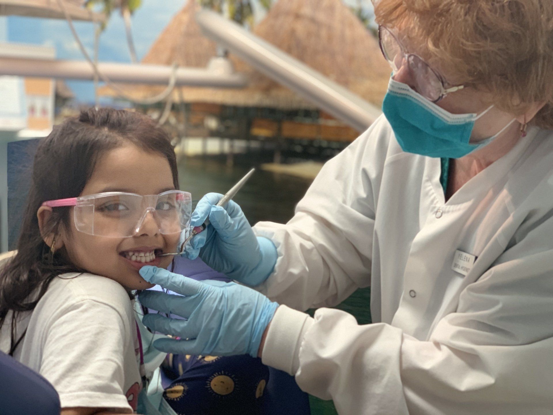 dentist checking little girl's teeth